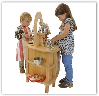 Zwei Kinder unterschiedlichen Alters stehen jeweils an einer Seite der Spielküche