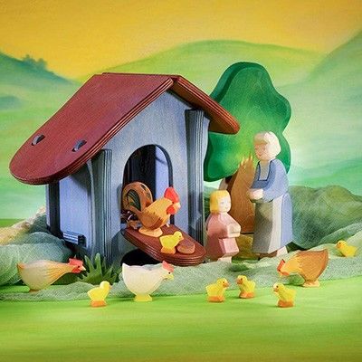 Eine Szenerie aus Holzfiguren zeigt einen Hühnerstall mit Hahn, Hennen, Küken, einer Bäuerin und einem Mädchen.