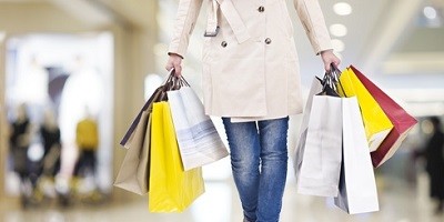 Frau beim Shoppen trägt 8 Tüten durchs Einkaufcenter