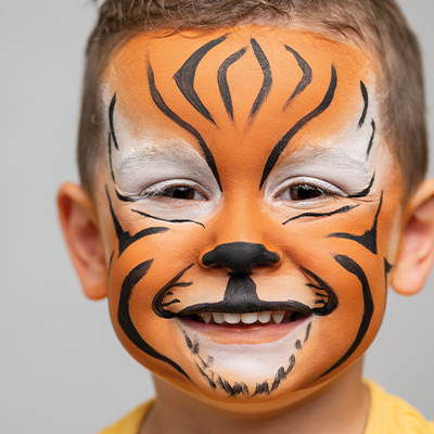 Junge mit einem geschminktem Tiger-Gesicht