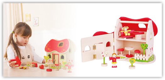 Mädchen spielt mit Puppenhaus aus Holz mit rotem Dach