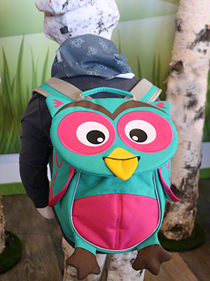Kind mit Eulen-Rucksack auf dem Rücken