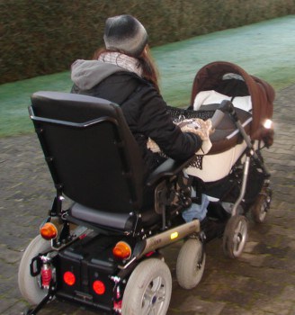 Mutter im Rollstuhl schiebt einen Kinderwagen