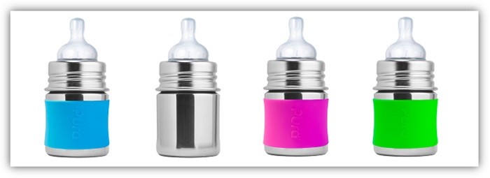Produktfoto von Babyflaschen aus Edelstahl, eine mit blauer Hülle, eine ohne, eine mit einer pinken und eine mit einer grünen Hülle