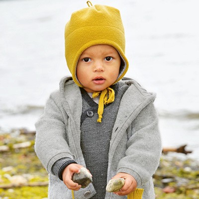 Kind ist mit Pullover, Jacke und Mütze gut gerüstet für einen Spaziergang draußen