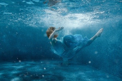 Mädchen ist im Kleid ins Wassergefallen und geht unter