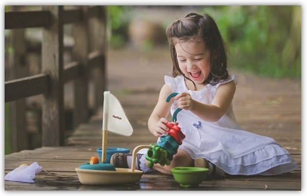 Mädchen spielt draußen mit dem Wasserspielzeug von PlanToys