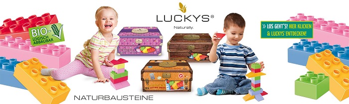 Banner mit den Bausteinen, zwei Kindern, die damit spielen und drei Sets, die in Kisten verpackt sind, die wie Koffer aussehen