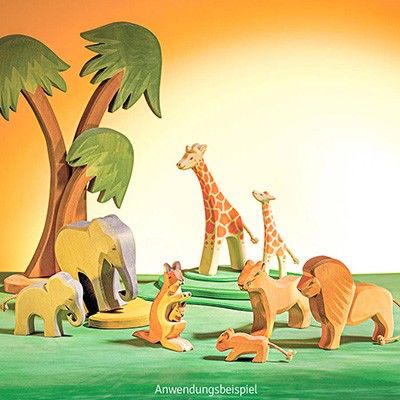 Eine Szenerie aus Holzfiguren zeigt die Savanne mit Elefanten, Giraffen, Löwen und Kängurus.